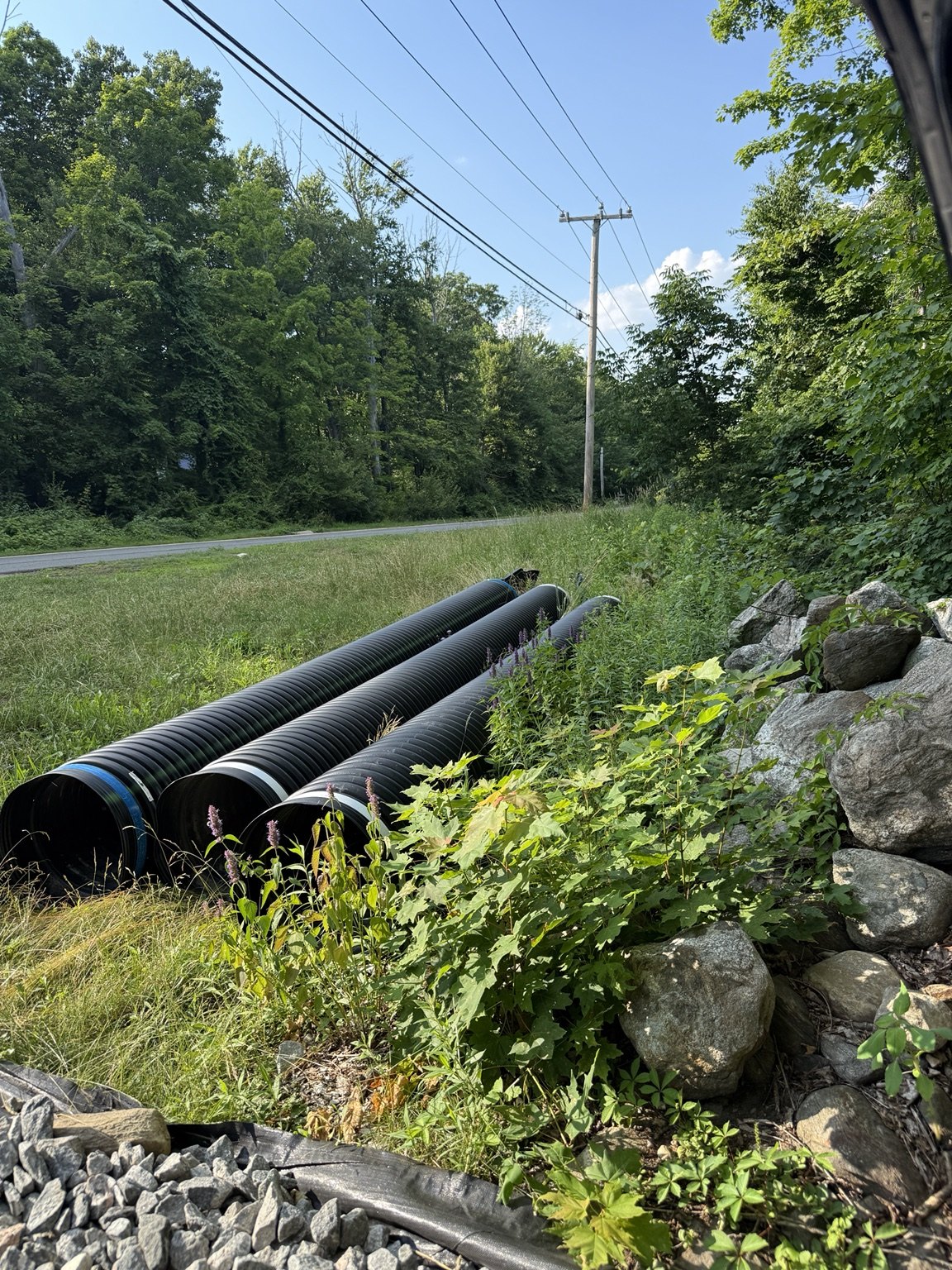 Culvert pipes staged near roadway
